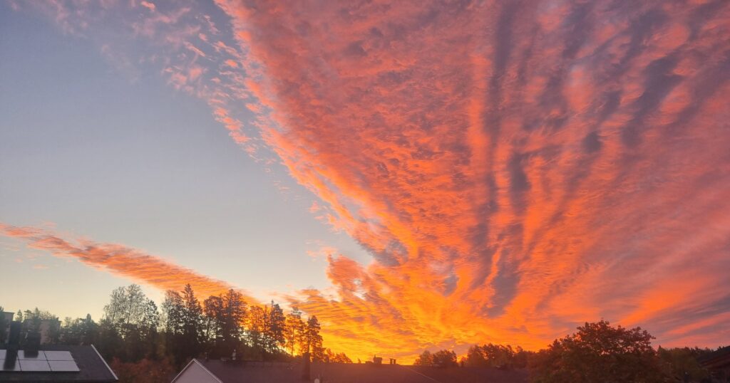 オレンジ色の雲が広がる夕焼けの空。未来への希望を象徴するイメージ