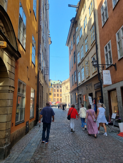 スウェーデンの旧市街の街並みを歩く人々の写真。お金の価値観の違いをテーマにした記事のイメージとして使用。