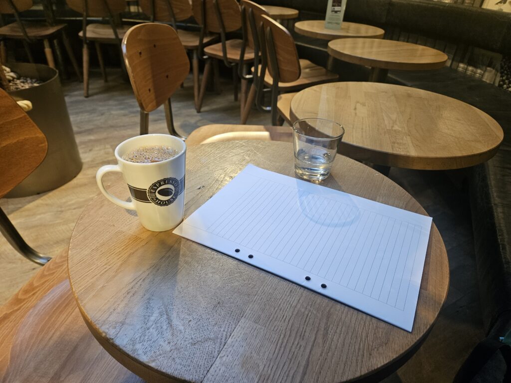 ノートPCとコーヒーが置かれた静かなデスク。集中投資のための企業分析を象徴する写真。