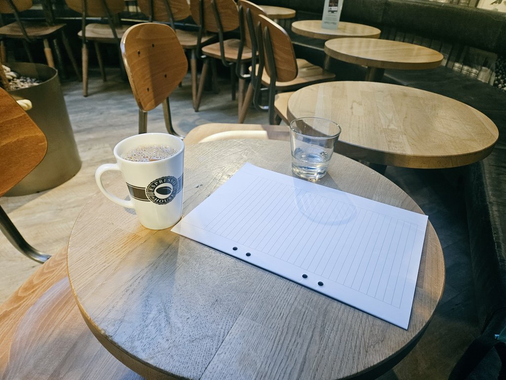 ノートとコーヒーが置かれた静かなデスク。副業や自己投資の時間を象徴する写真。